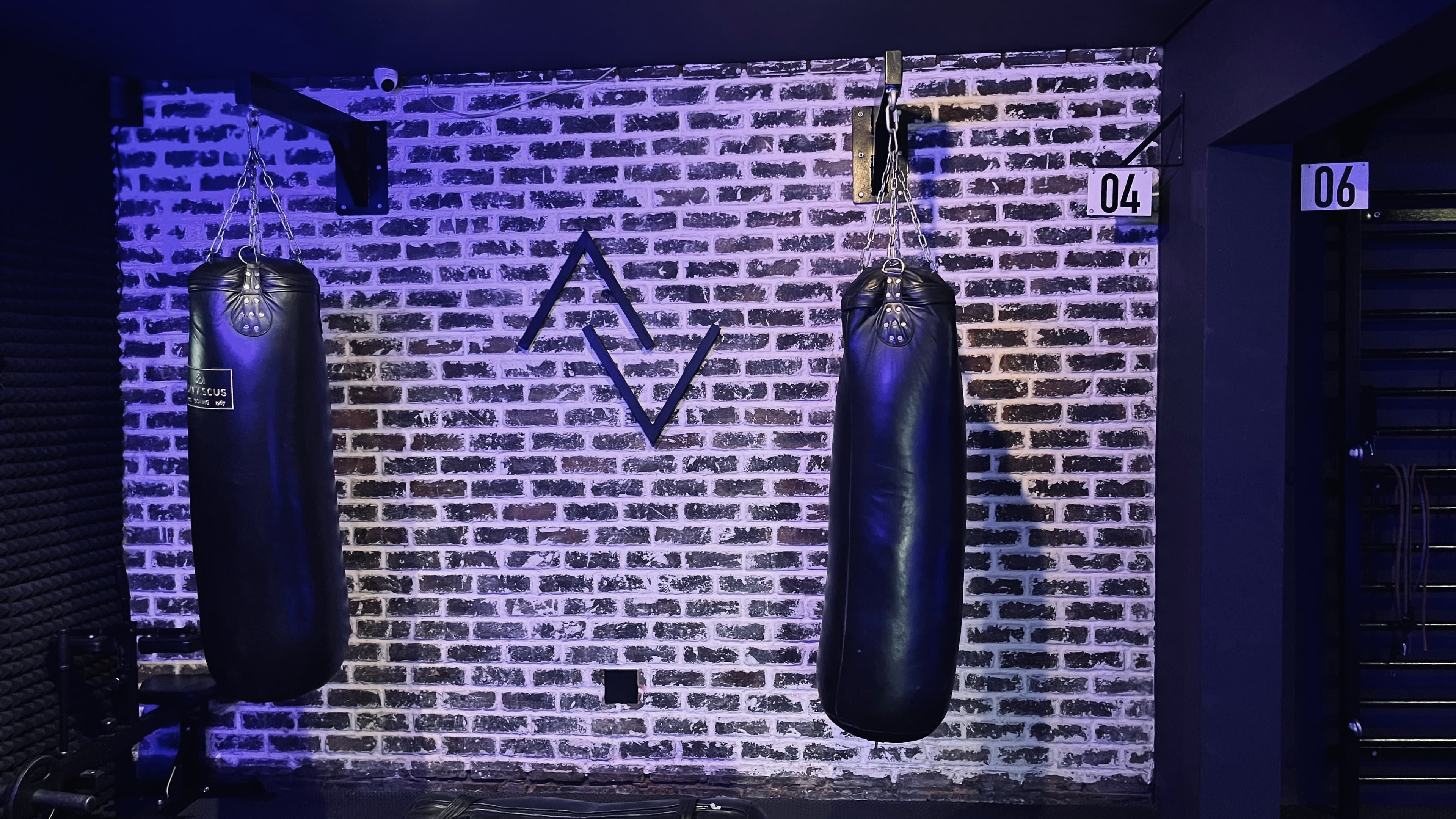 Heavy boxing bags mounted on the brick wall at TENROUNDS Garsfontein