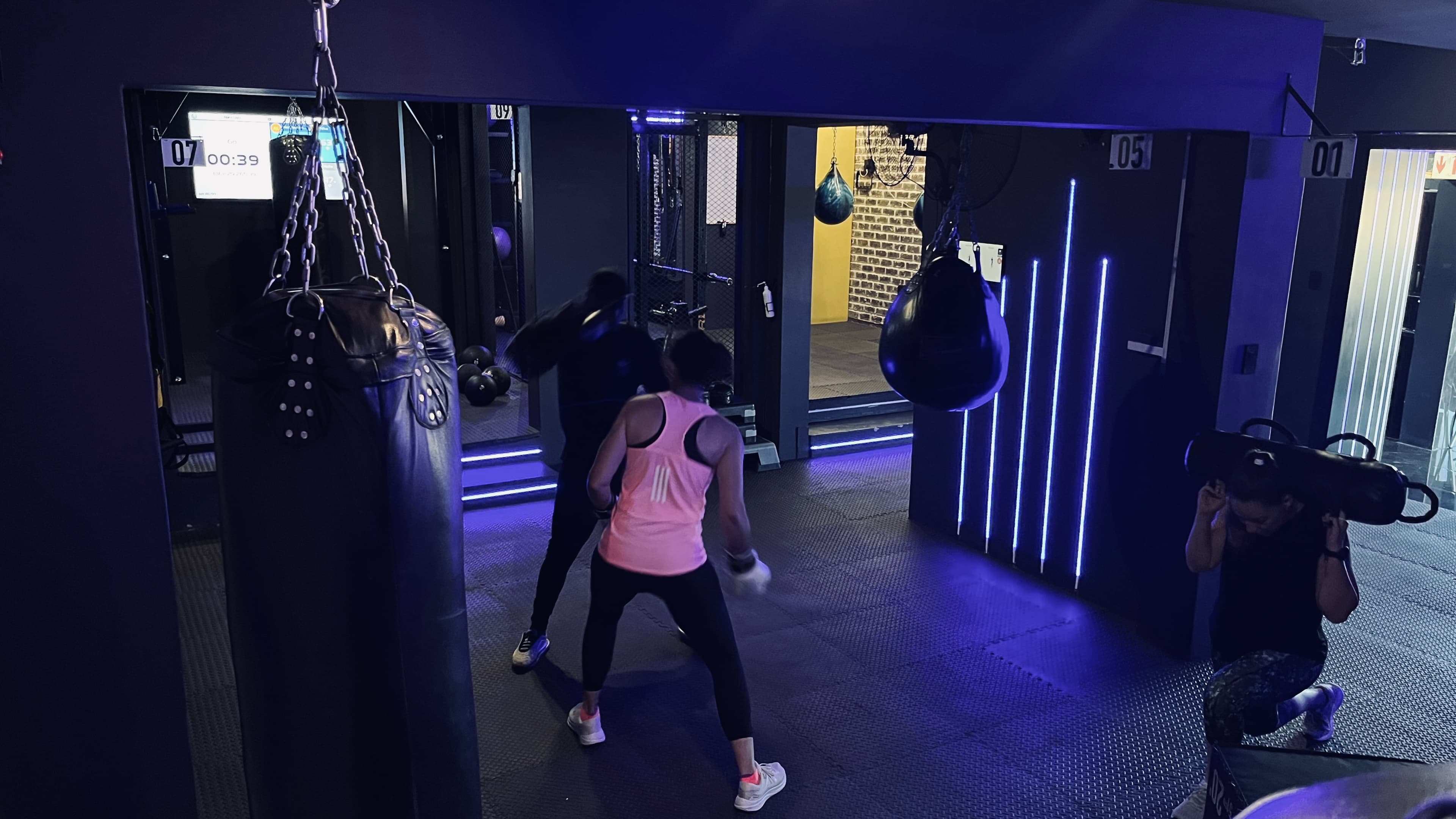 Members training together at the boxing heavy bags during a TENROUNDS group workout