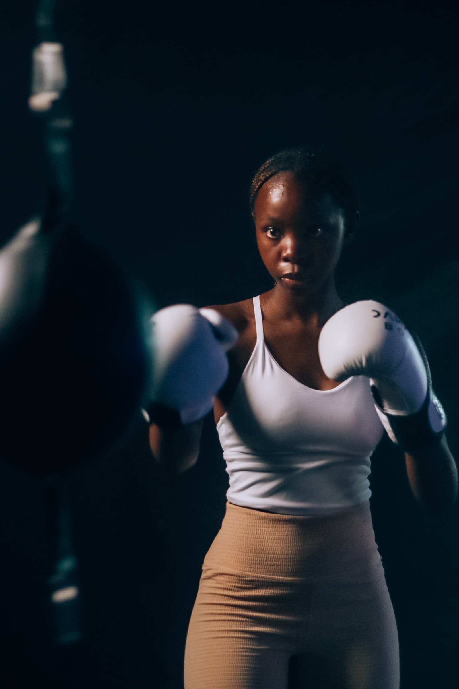Member boxing in a dramatic spotlight during a TENROUNDS class in Garsfontein