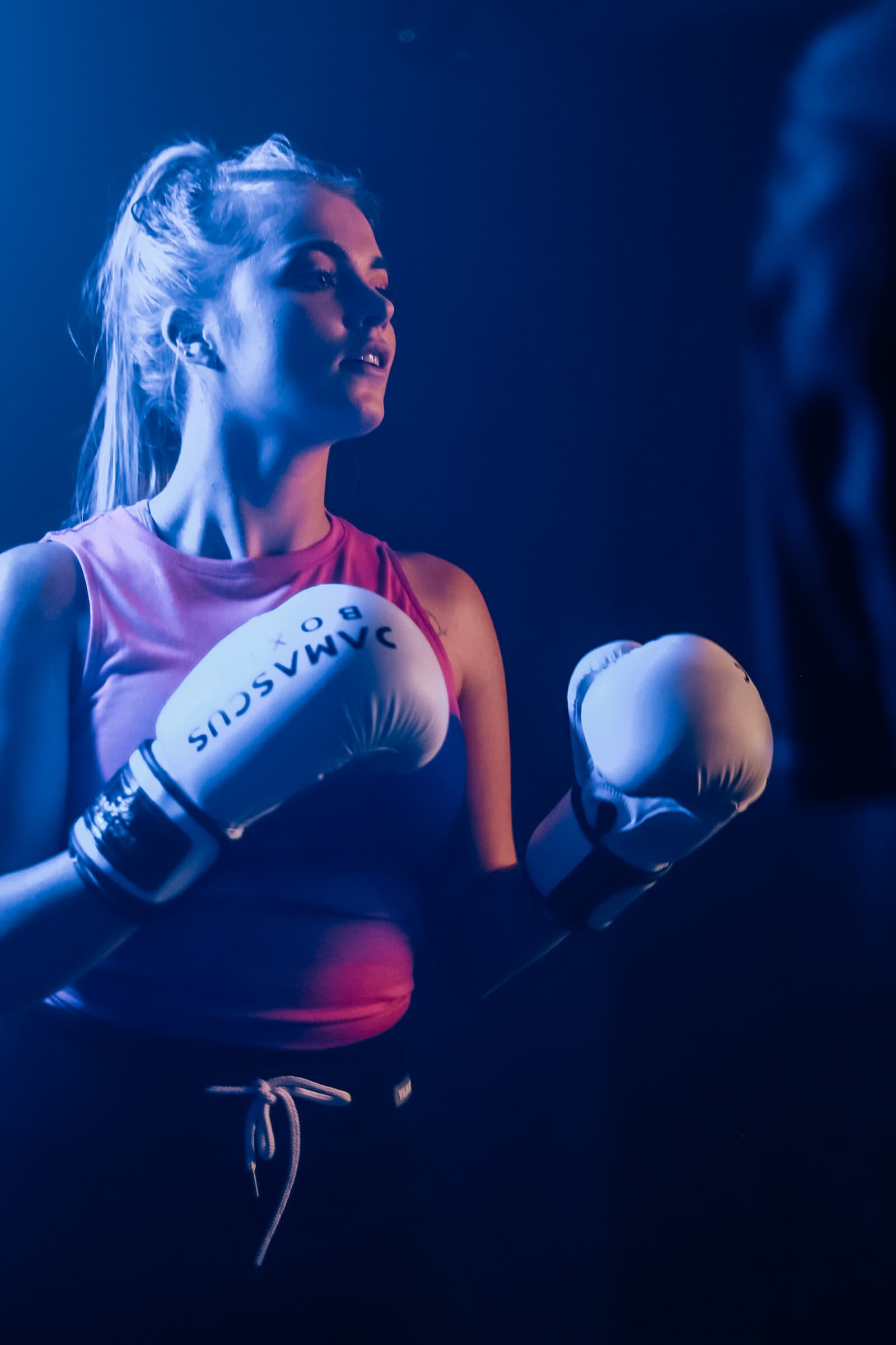 Portrait of a female member with boxing gloves at TENROUNDS