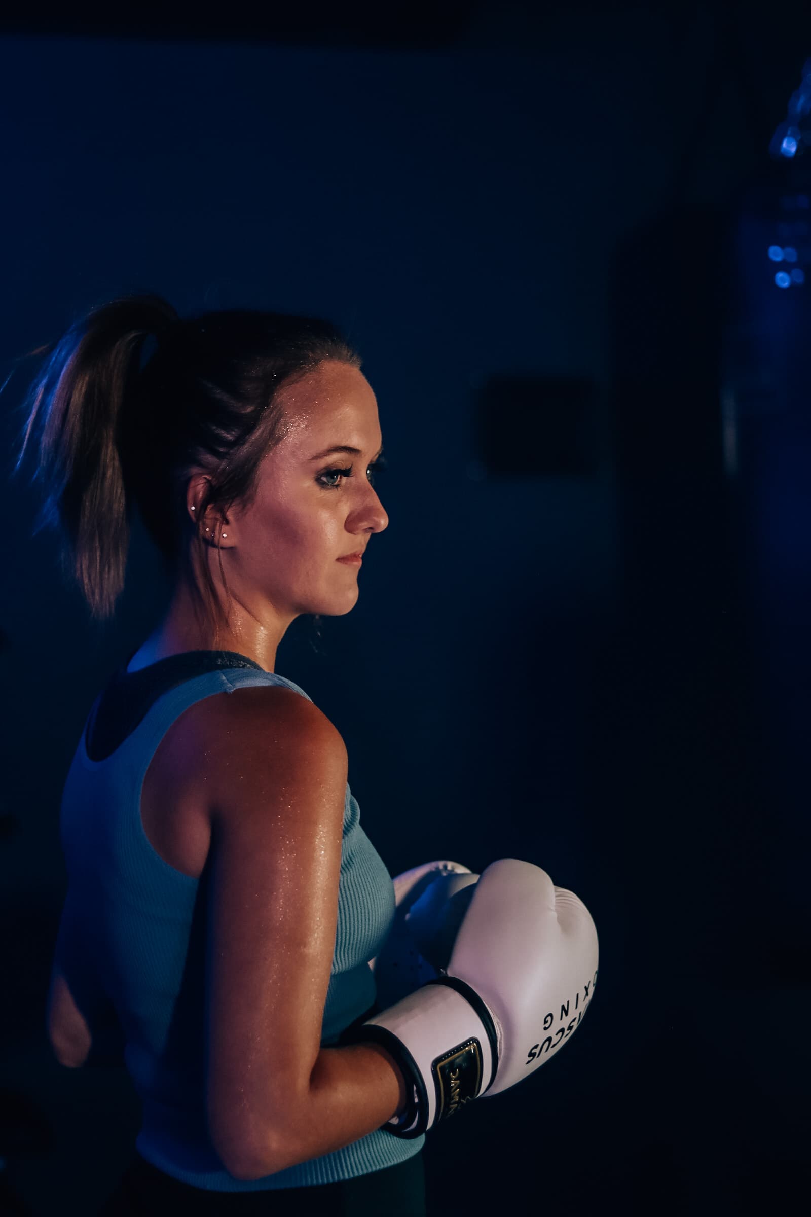 Focused female boxer in profile during a TENROUNDS heart-rate-guided session