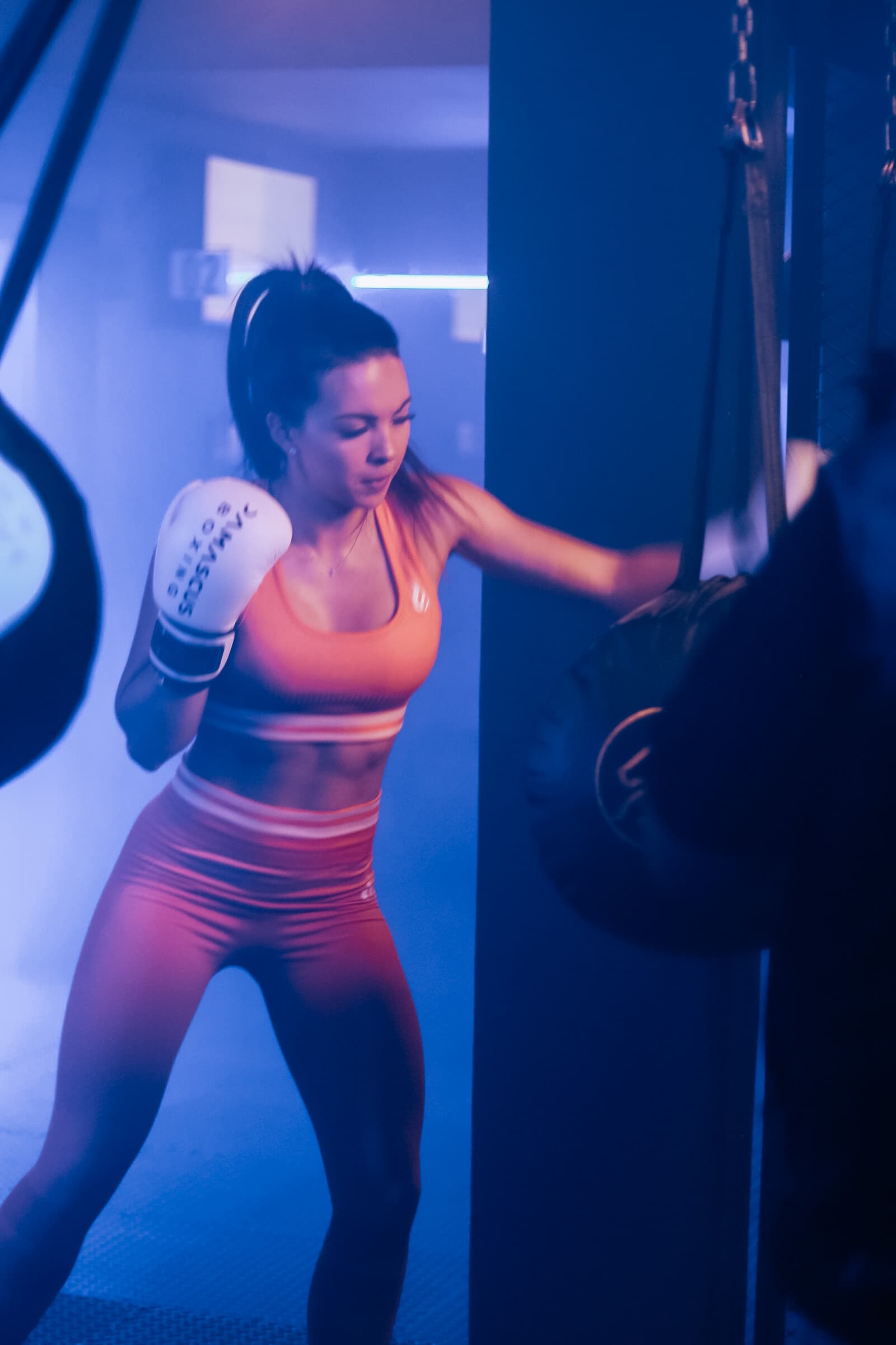 Member throwing punches at a heavy bag during a TENROUNDS boxing workout