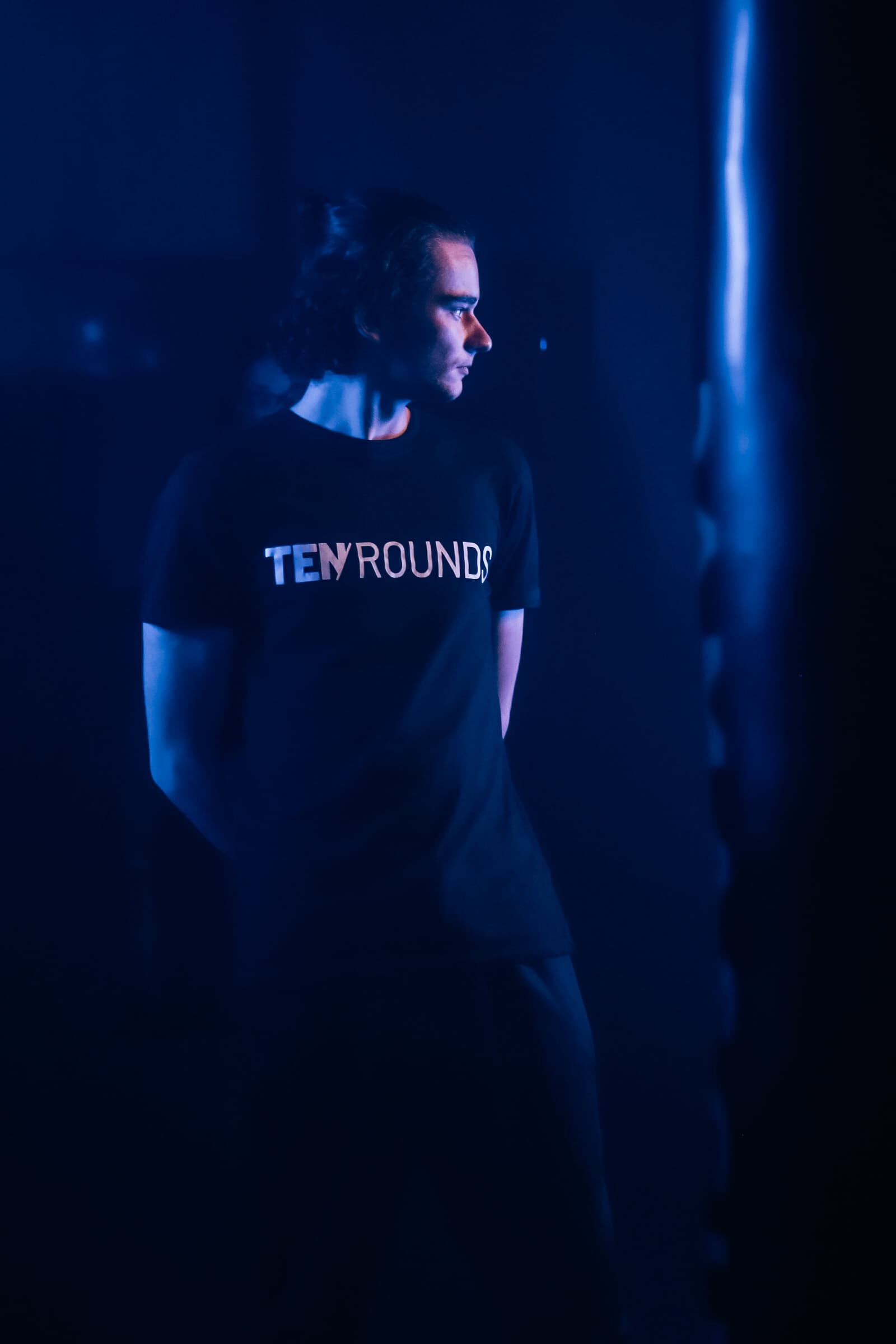 Member wearing TENROUNDS apparel under blue gym lighting